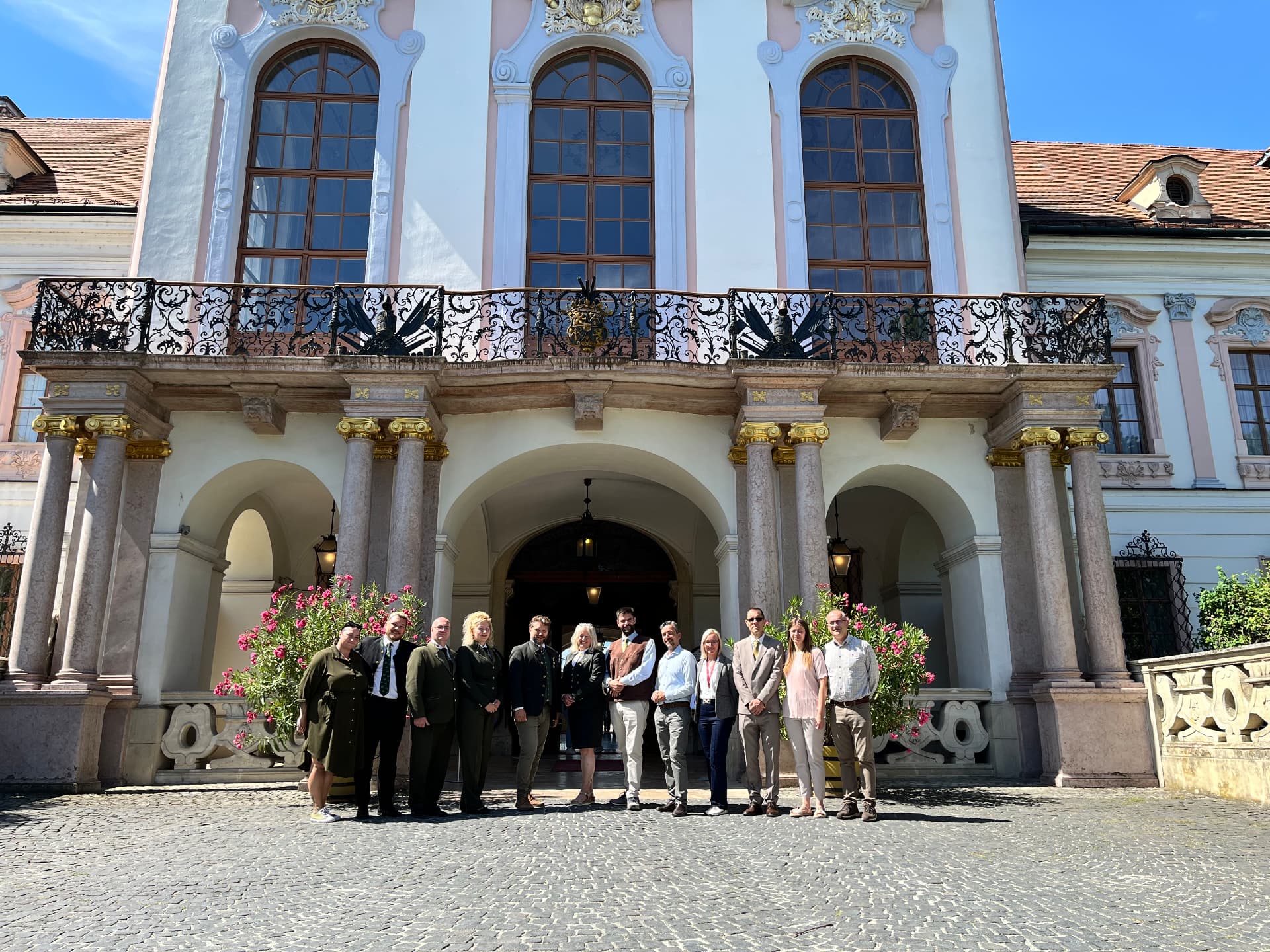 The organising team of the European Hunting Horn Players Championship in front of the Royal Palace of Gödöllő